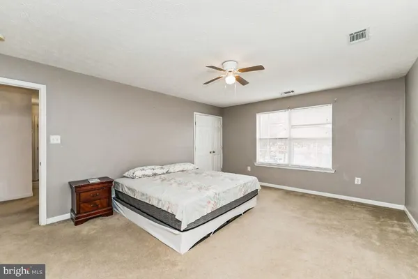 a spacious bedroom with a bed and a window