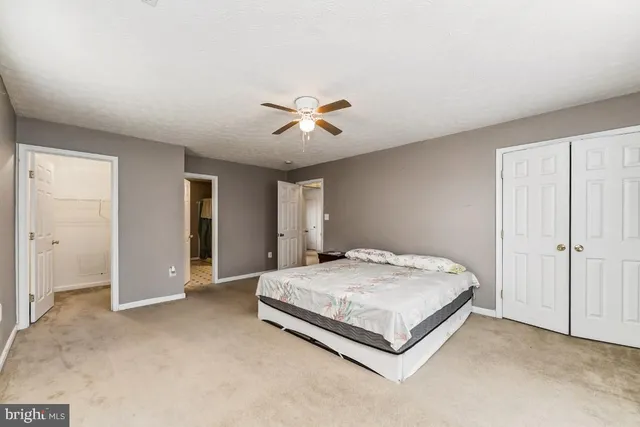 a spacious bedroom with a bed and a chandelier