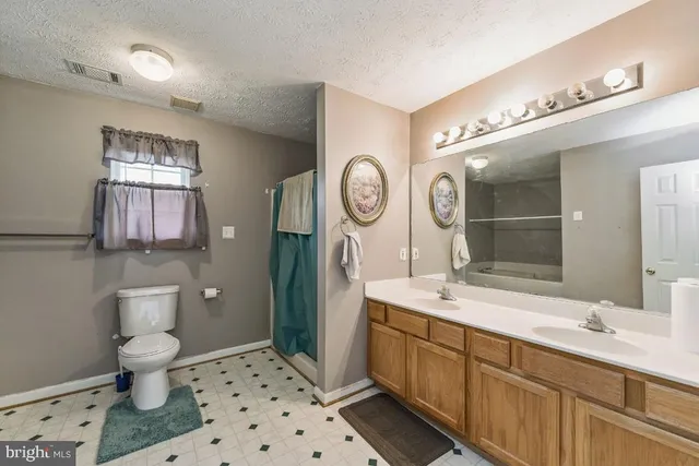 a spacious bathroom with a sink a toilet and a mirror
