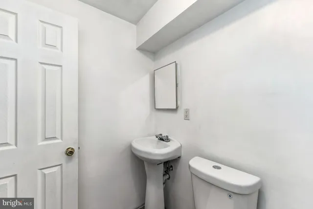 a bathroom with a sink a toilet and mirror