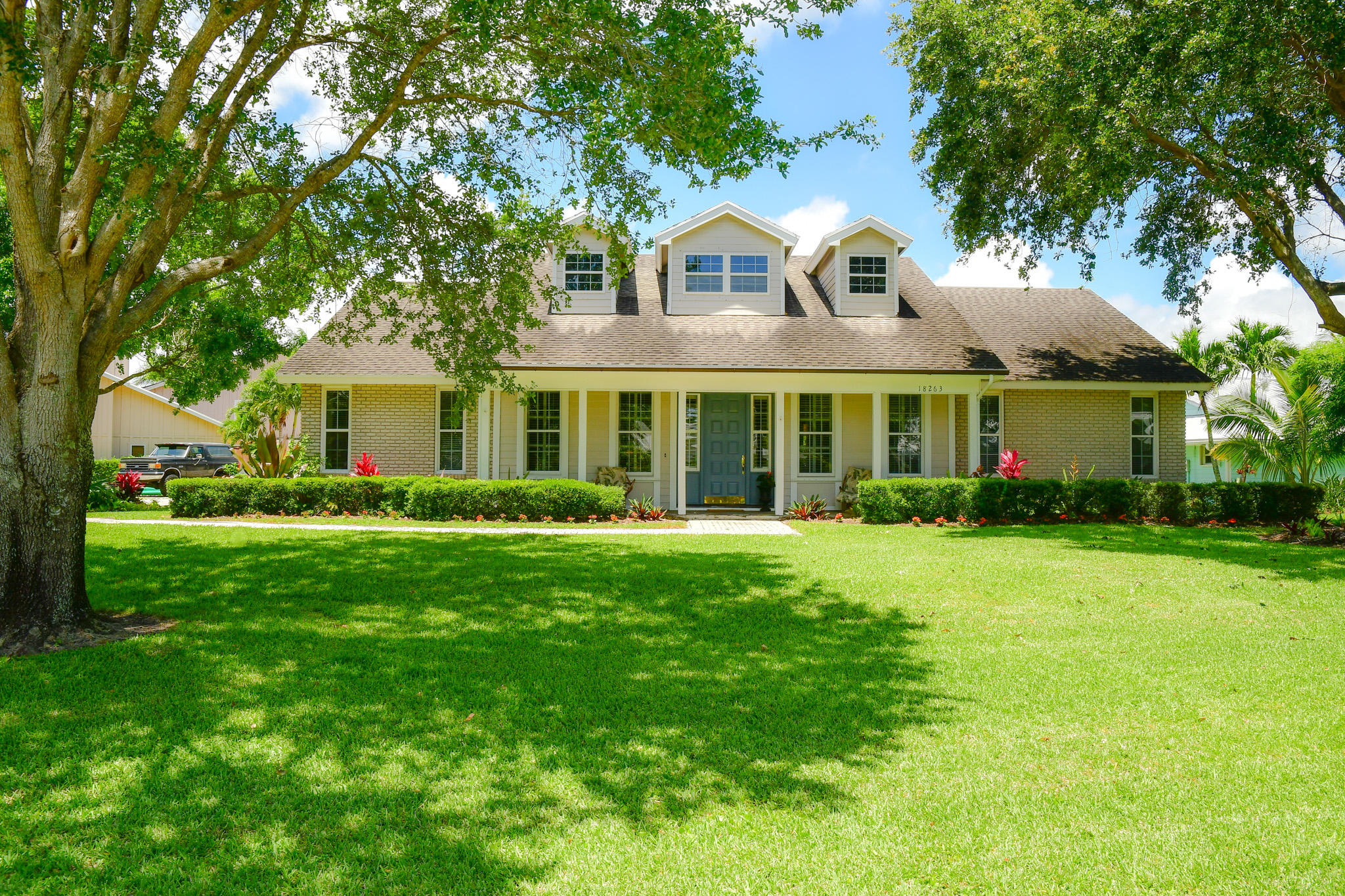 18263 River Oaks Drive Jupiter, FL 33458 - Photo 1 of 24 a front view of a house with a yard