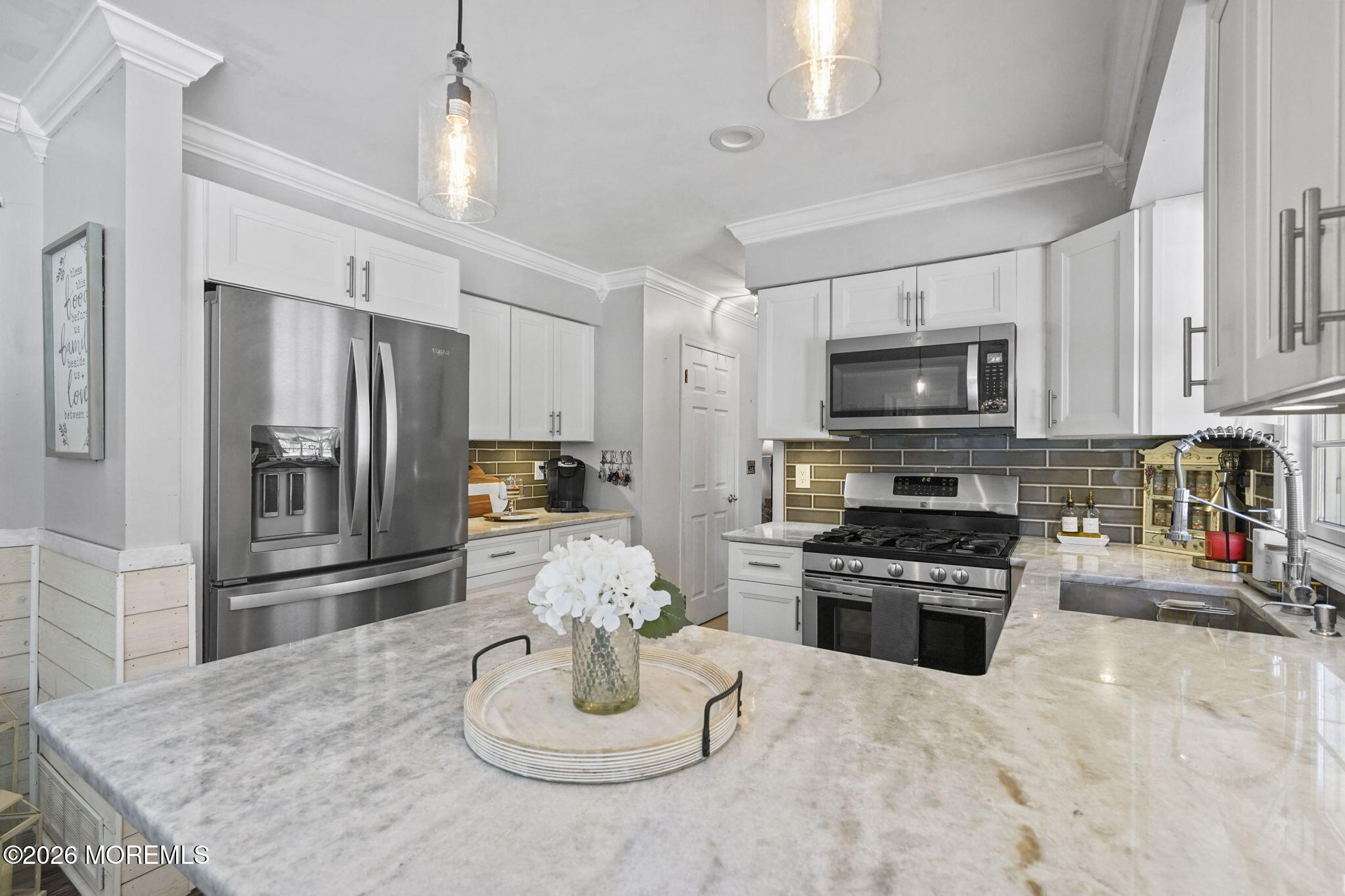 12 Rimwood Lane Howell, NJ 07731 - Photo 5 of 34 a kitchen with stainless steel appliances kitchen island granite countertop a refrigerator a stove top oven a sink a dining table and chairs with wooden floor