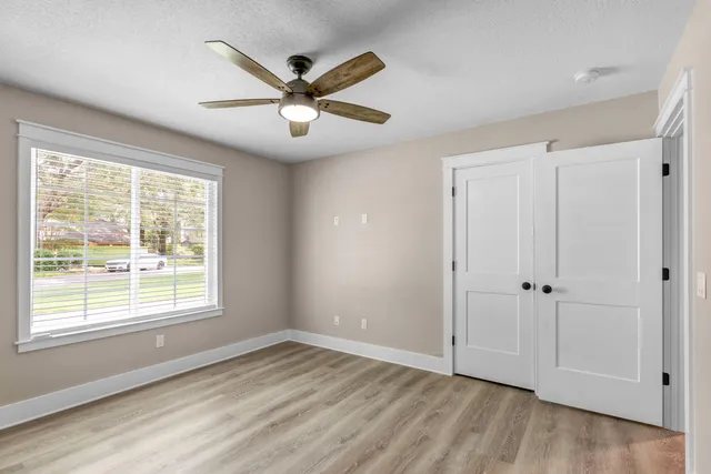 a view of a livingroom with a ceiling fan and wooden floor