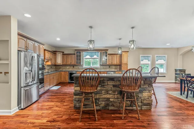 a kitchen with stainless steel appliances kitchen island granite countertop a stove top oven and a sink