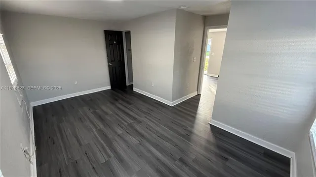 an empty room with wooden floor and closet