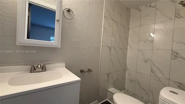 a bathroom with a sink toilet and shower
