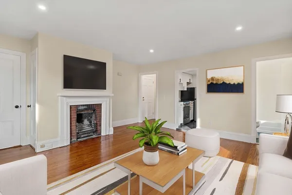 a dining room with furniture a fireplace and wooden floor