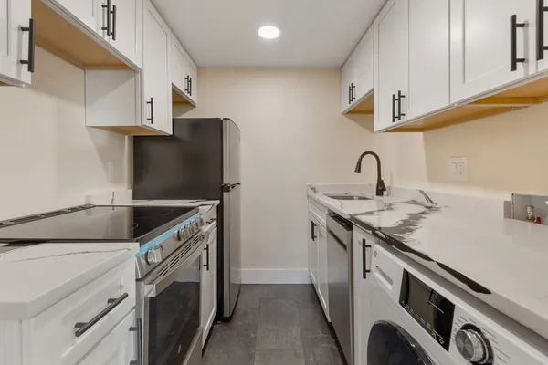 a kitchen with stainless steel appliances granite countertop a sink stove and refrigerator