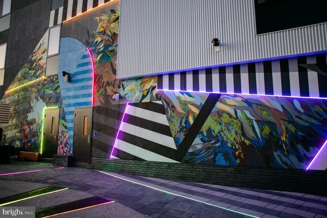 a front view of multi story residential apartment building with yard and sign board