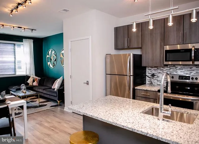 a kitchen with kitchen island a stove and a refrigerator