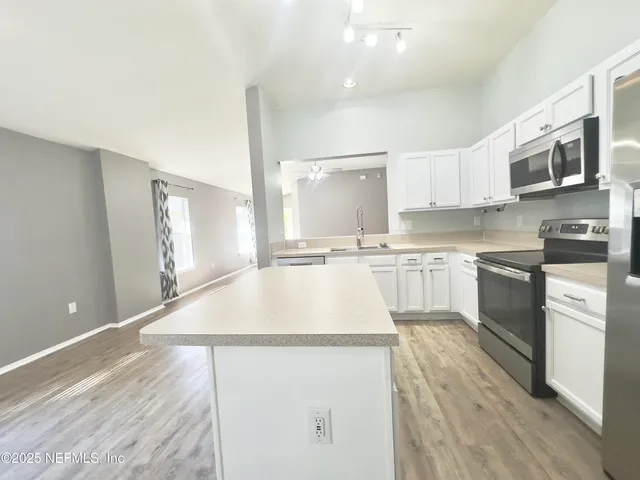 a kitchen with stainless steel appliances a refrigerator sink and stove