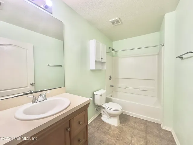 a bathroom with a granite countertop sink toilet a mirror and shower