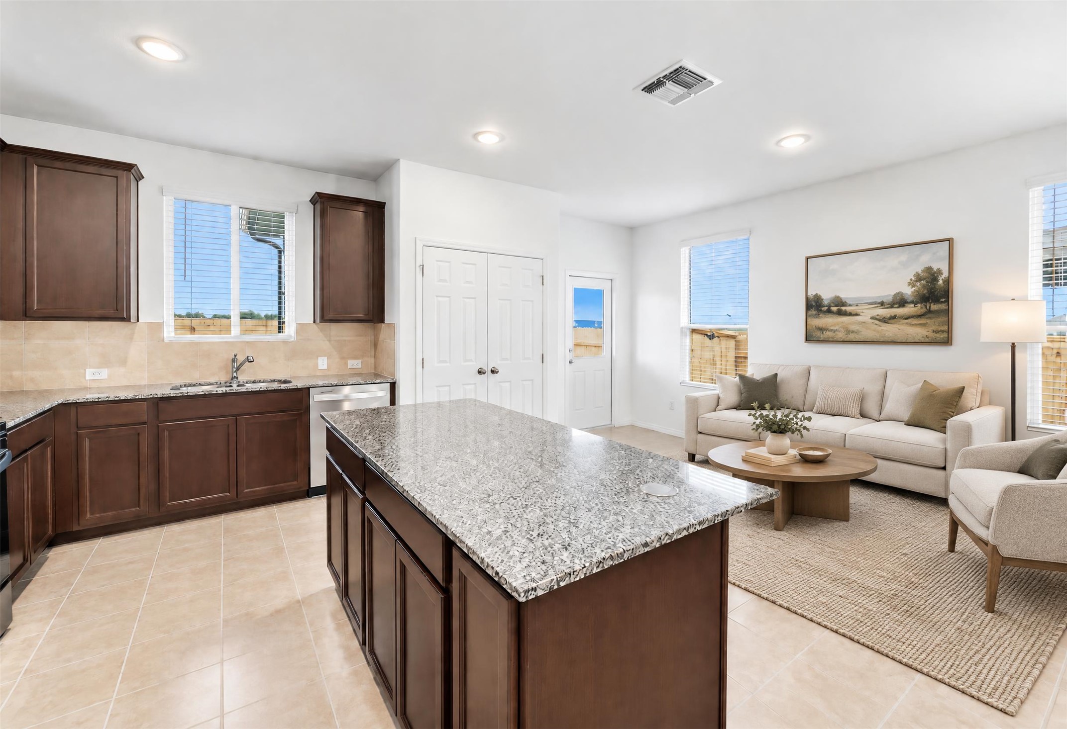 545 Henry Milton Road Georgetown, TX 78626 - Photo 5 of 33 Granite countertops and an expansive kitchen island seamlessly connect to the inviting living area.