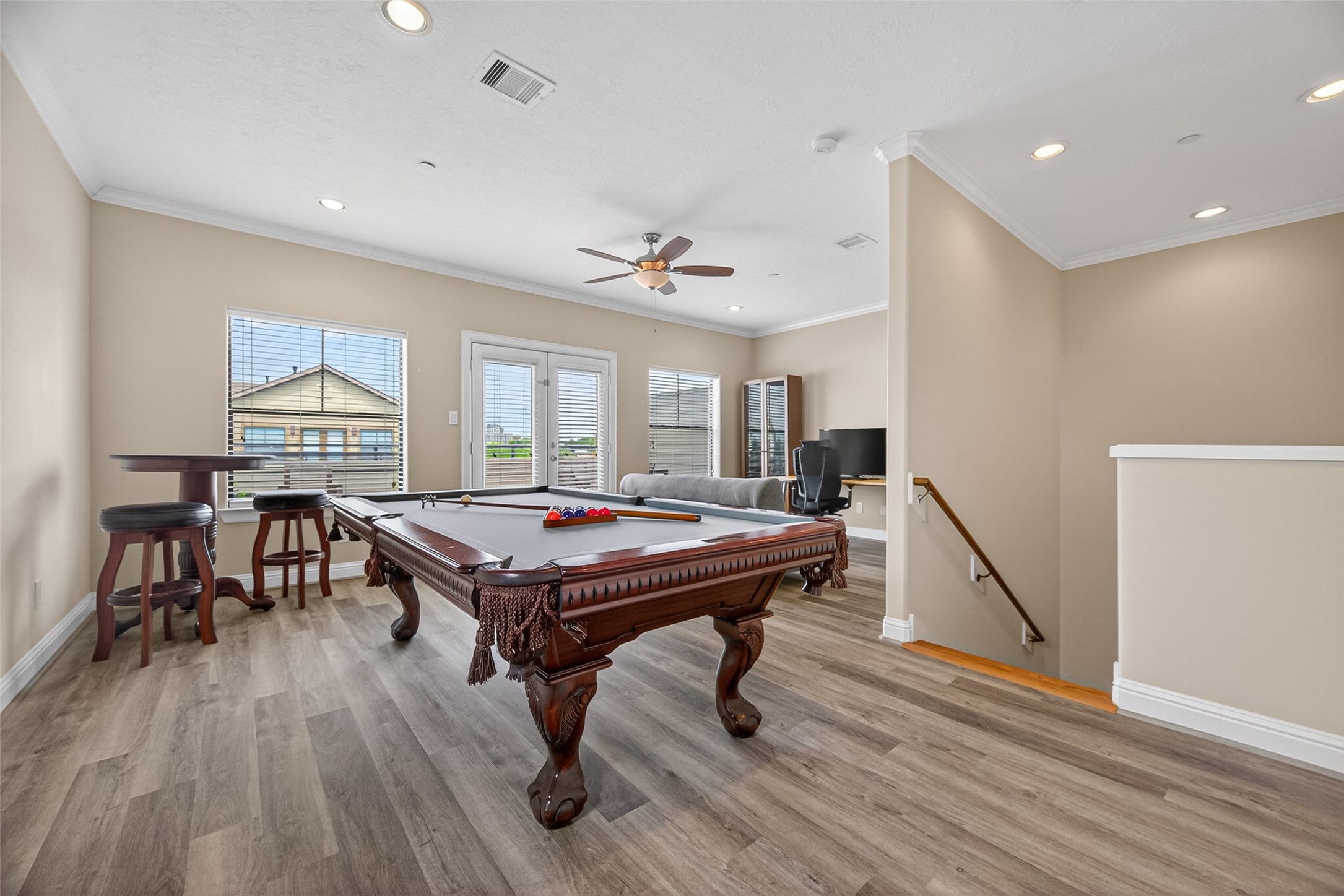 2611 Riverside Drive, Unit C Houston, TX 77004 - Photo 11 of 50 This spacious and inviting game room features a beautifully crafted pool table, elegant wood flooring, and plenty of natural light from large windows. It's perfect for entertainment and relaxation.