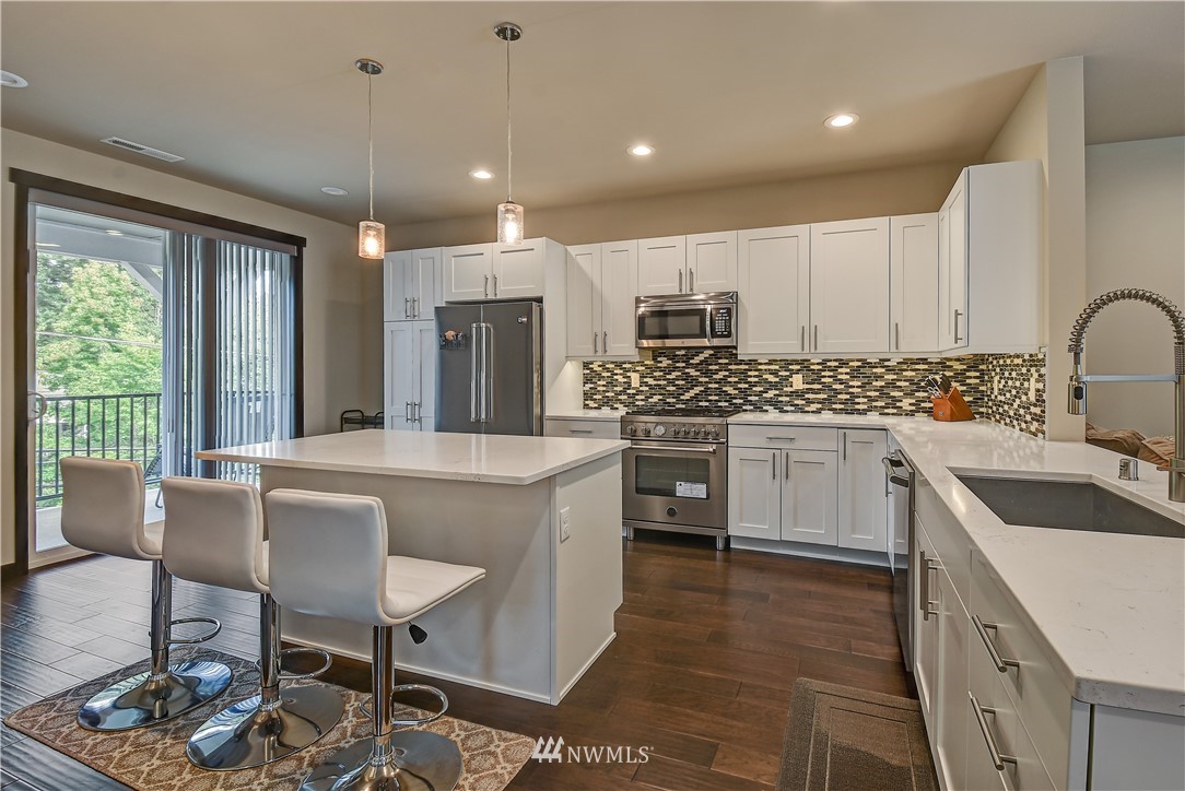 22806 23rd Avenue Southeast, Unit 1 Bothell, WA 98021 - Photo 5 of 20 a kitchen with kitchen island granite countertop a sink cabinets and stainless steel appliances