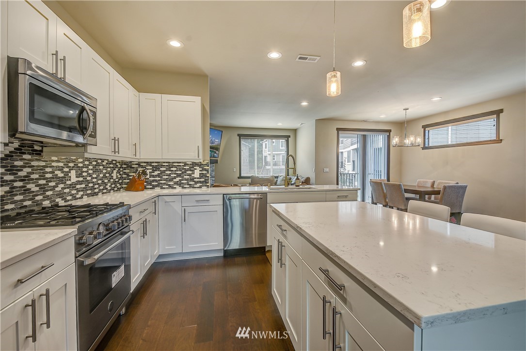 22806 23rd Avenue Southeast, Unit 1 Bothell, WA 98021 - Photo 7 of 20 a large kitchen with stainless steel appliances granite countertop a lot of counter space and wooden floor