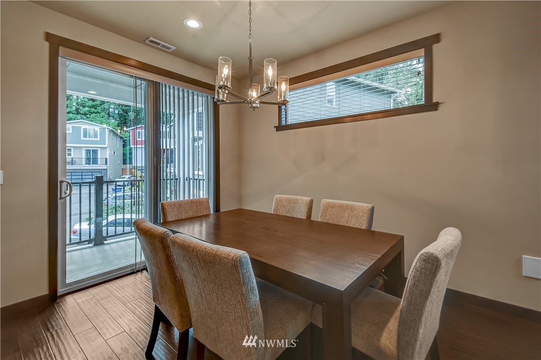 22806 23rd Avenue Southeast, Unit 1 Bothell, WA 98021 - Photo 9 of 20 a view of a dining room with furniture wooden floor and a chandelier