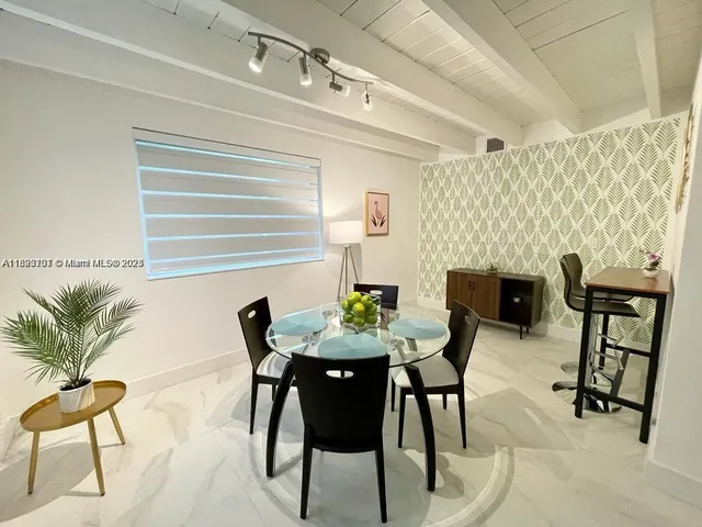 a view of a dining room with furniture and a potted plant