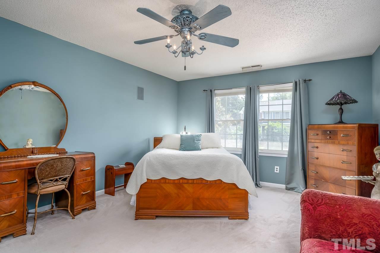 2308 Bolingbrook Lane Raleigh, NC 27613 - Photo 18 of 30 a spacious bedroom with a bed and a chandelier