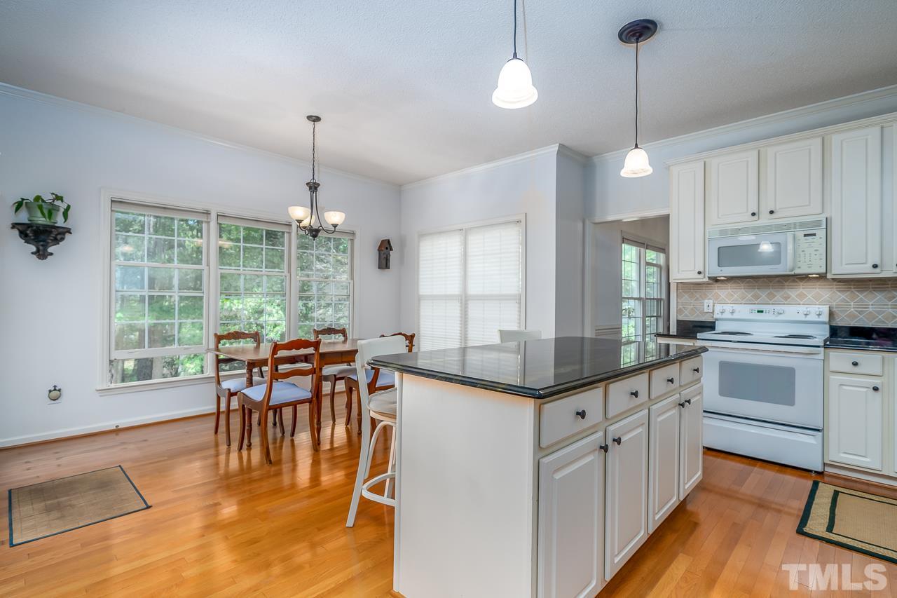 2308 Bolingbrook Lane Raleigh, NC 27613 - Photo 10 of 30 a kitchen with stainless steel appliances granite countertop dining table chairs and white cabinets