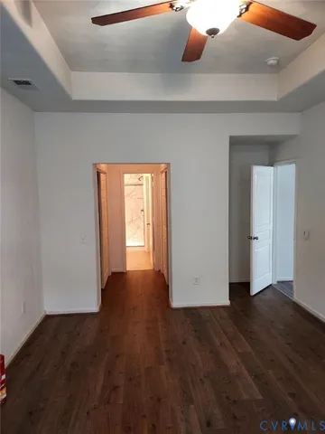 a view of an empty room with wooden floor and closet