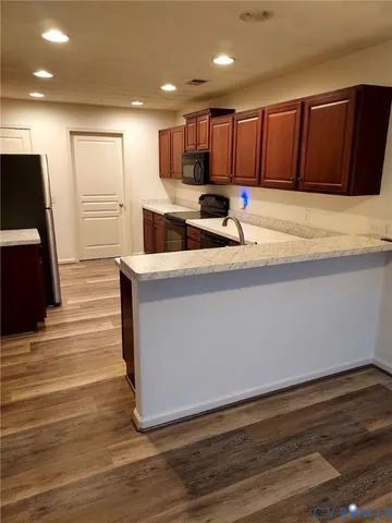 a kitchen with stainless steel appliances granite countertop a sink and a refrigerator