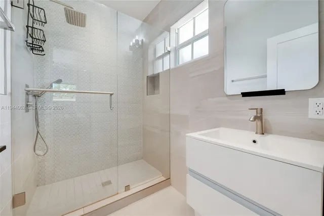 a bathroom with a shower a sink and a mirror