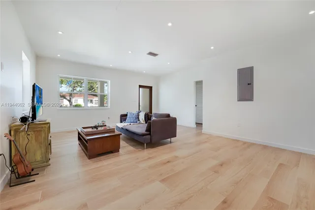 a living room with furniture flat screen tv and window
