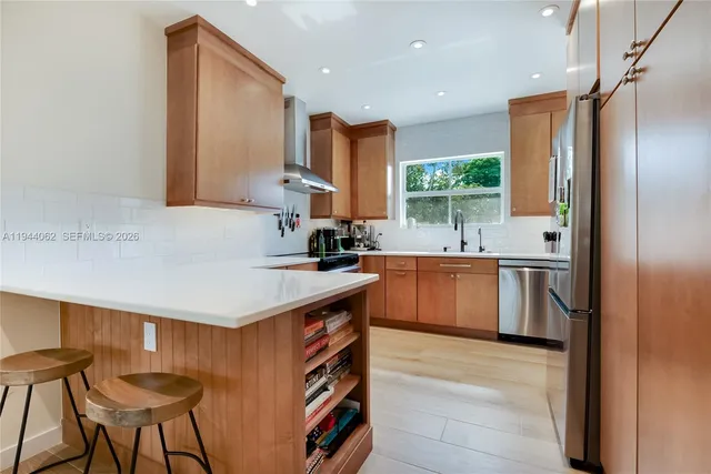 a kitchen with stainless steel appliances granite countertop a sink a stove a refrigerator and island