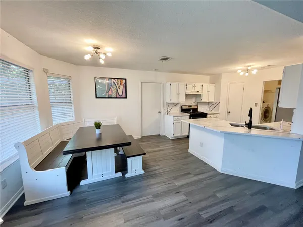 a living room with stainless steel appliances kitchen island granite countertop furniture wooden floor and a window