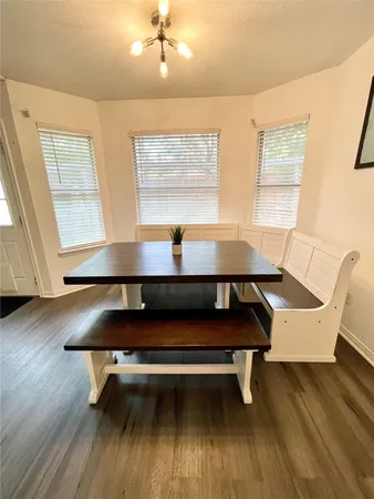 a sitting room with wooden floor pool table and windows