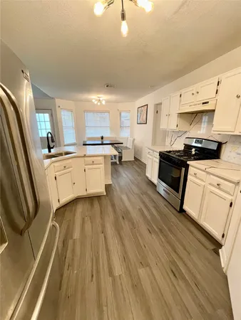 a kitchen with stainless steel appliances a stove a sink dishwasher and a refrigerator