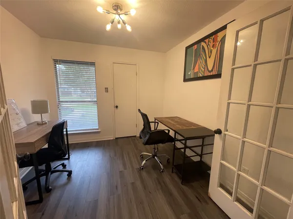 a view of a workspace with furniture and a window