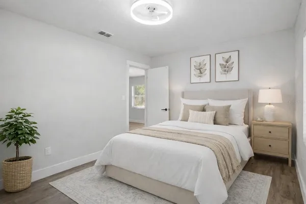 an empty room with wooden floor & windows