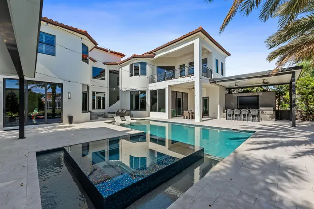 a view of a house with a swimming pool and sitting area