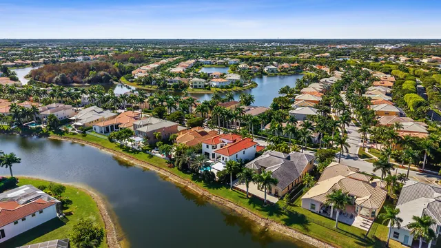 an aerial view of residential houses with outdoor space and lake view