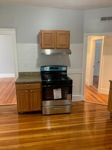 a kitchen with granite countertop a stove and a microwave
