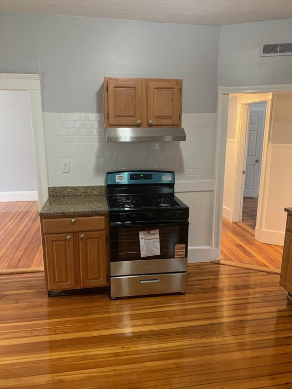 a kitchen with granite countertop a stove and a microwave
