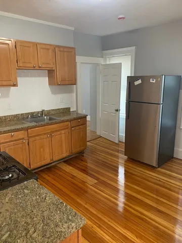 a kitchen with stainless steel appliances granite countertop a refrigerator and a sink
