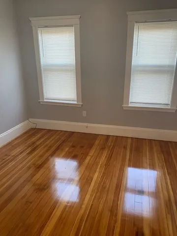 a view of a room with wooden floor and window