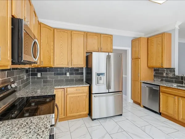 a kitchen with granite countertop a refrigerator and a sink
