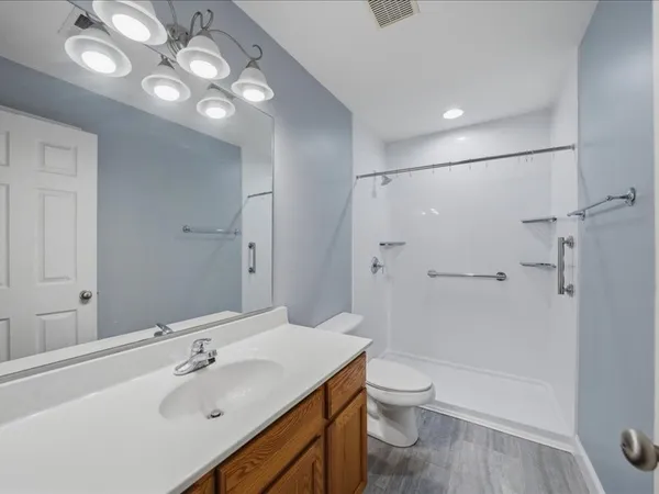 a bathroom with a sink a toilet and shower