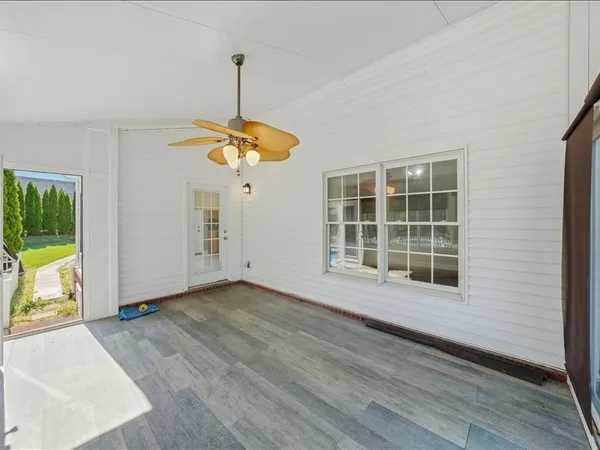 a view of a room with a large window and wooden floor