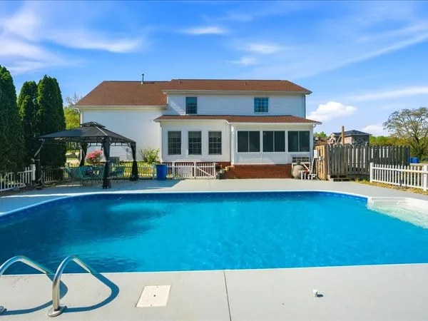 a view of swimming pool with lawn chairs and plants