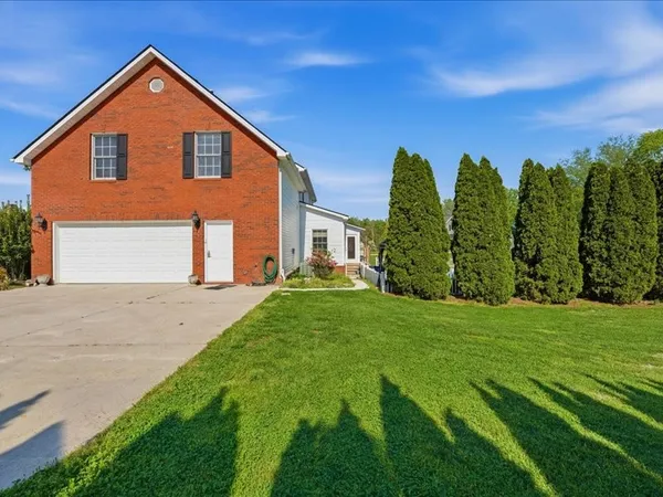 a front view of a house with a yard and trees