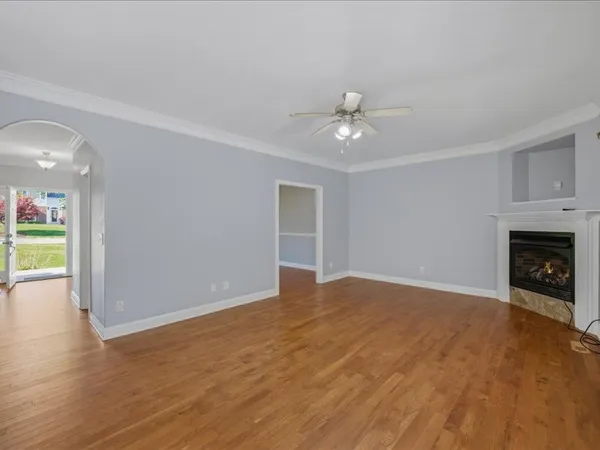 a view of an empty room with a fireplace and a window
