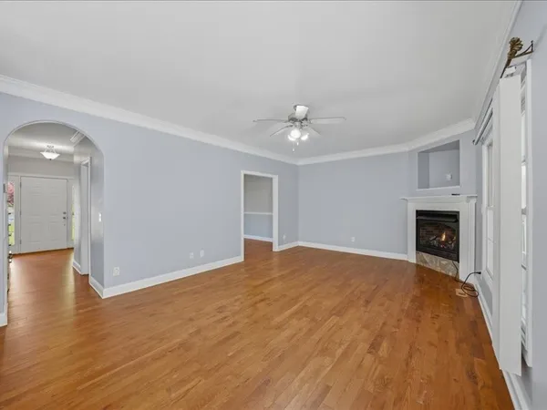 a view of empty room with wooden floor and fireplace