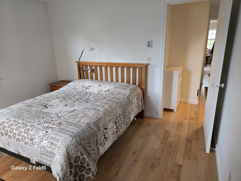 222 Buck Island Road, Unit 45 Yarmouth, MA 02673 - Photo 19 of 26 a bedroom with a bed and wooden floor