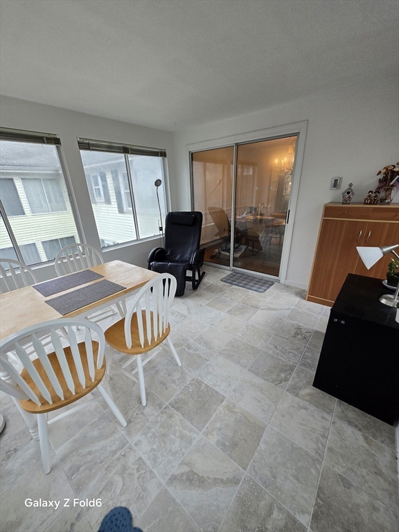 222 Buck Island Road, Unit 45 Yarmouth, MA 02673 - Photo 10 of 26 a living room with furniture and a floor to ceiling window