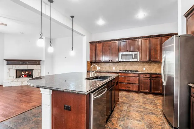 a kitchen with stainless steel appliances granite countertop a sink stove and refrigerator